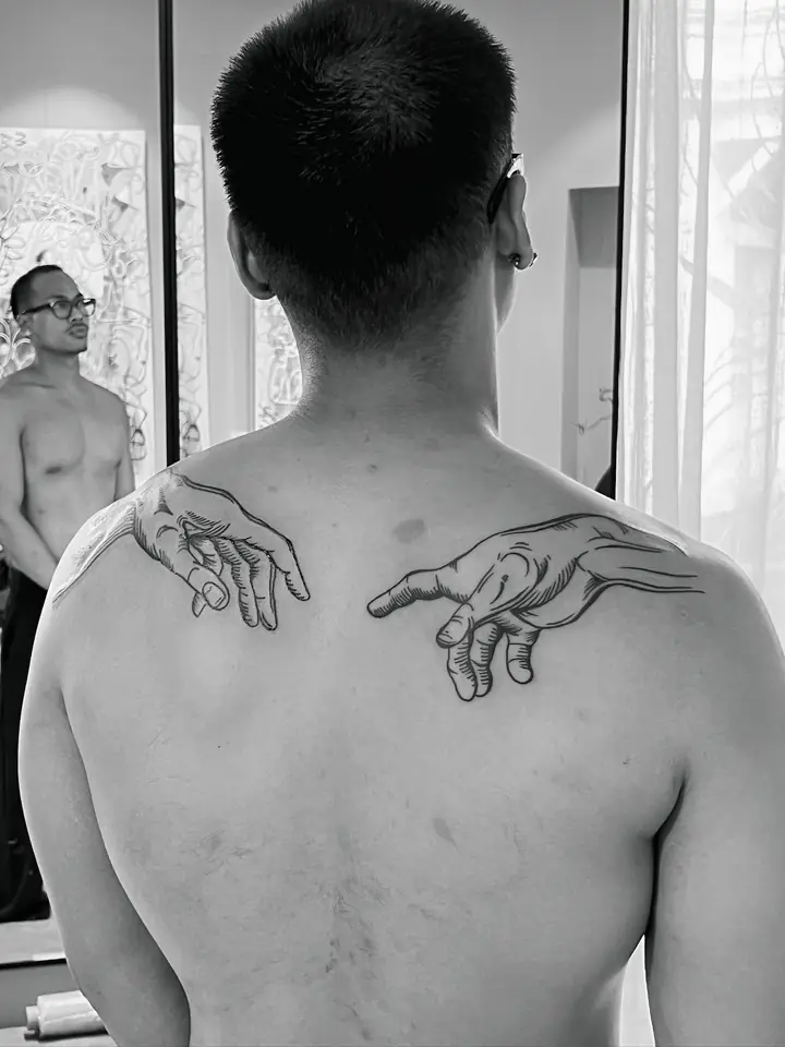 Hendene fra Skapelsen av Adam over skulderbladene, blackwork av Abas