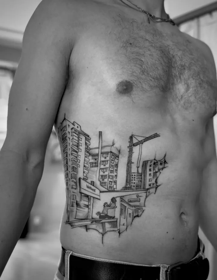 Bygninger og byggekran på siden av magen, blackwork av Camilla