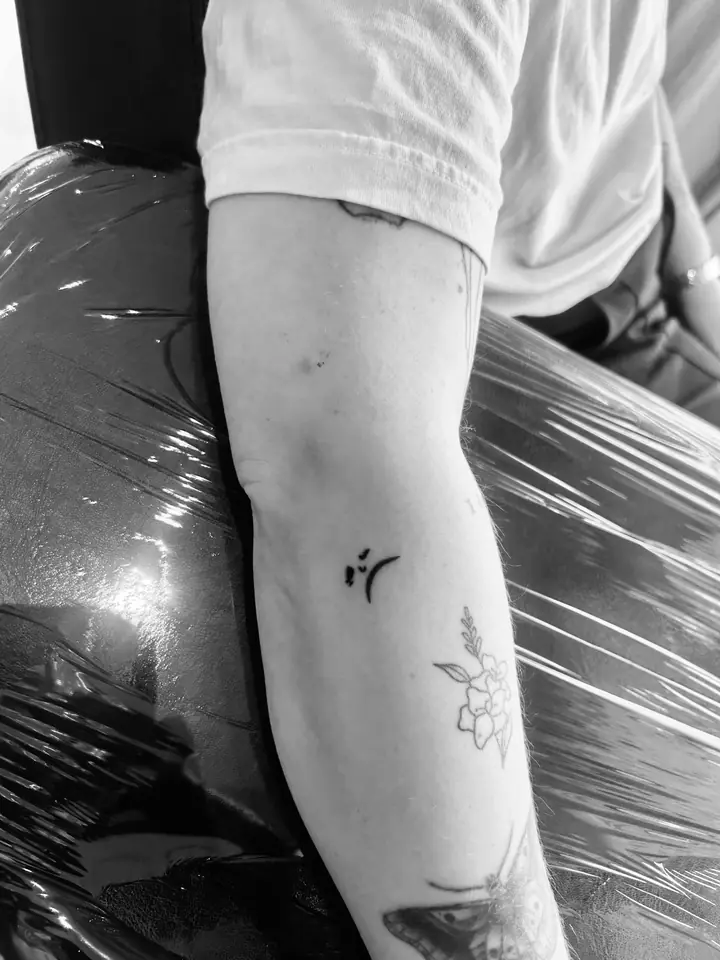 Lite symbol og blomst på armen, blackwork av Sandra
