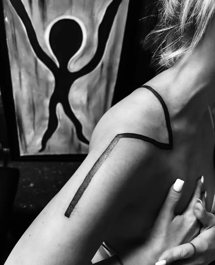 Tykk svart linje over skulderen og overarmen, blackwork av Sandra