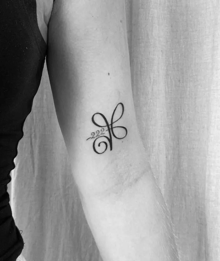 Symbol med tallet 222 på overarmen, blackwork av Vilde